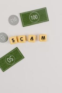 A minimal flat lay of a scam concept using dice and fake currency on a gray surface.