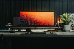 A sleek gaming desk setup featuring a modern monitor, keyboard, and decorative elements, ideal for gamers or professionals.
